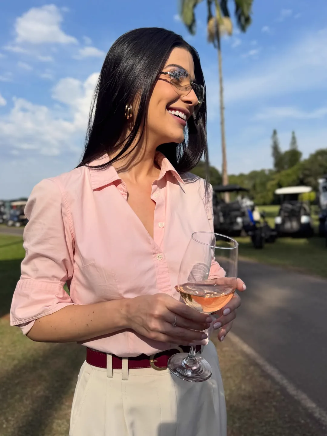 Míriam Braga em retrato externo com camisa rosa e óculos escuros